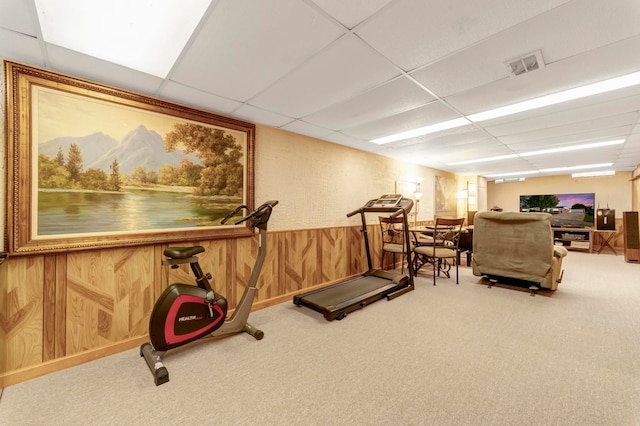 exercise area featuring a paneled ceiling and carpet floors