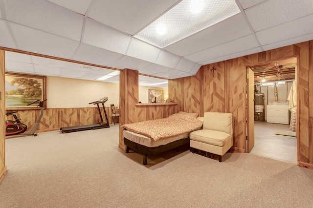 bedroom featuring washer / dryer, water heater, a drop ceiling, carpet floors, and wood walls