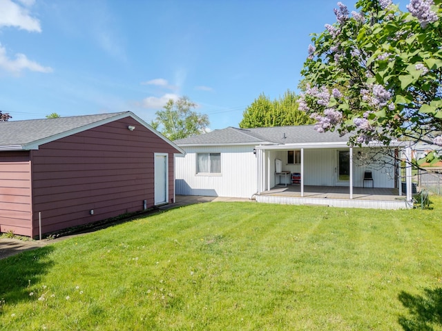 rear view of property with a yard and roof with shingles