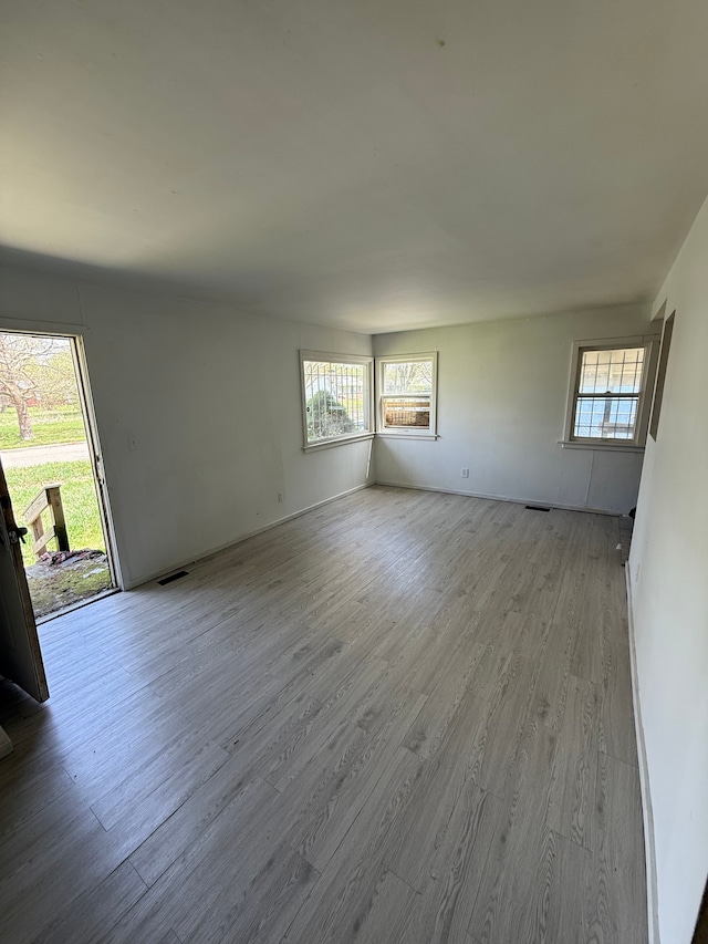 1710 Polly St, Flint, MI 48505 - spare room with a healthy amount of sunlight, visible vents, and wood finished floors
