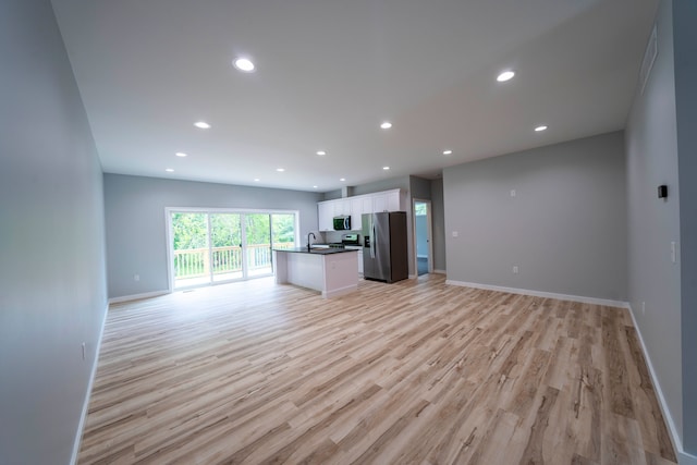 26015 E Huron River Dr, Flat Rock, MI 48134 - unfurnished living room with light wood finished floors, a sink, baseboards, and recessed lighting