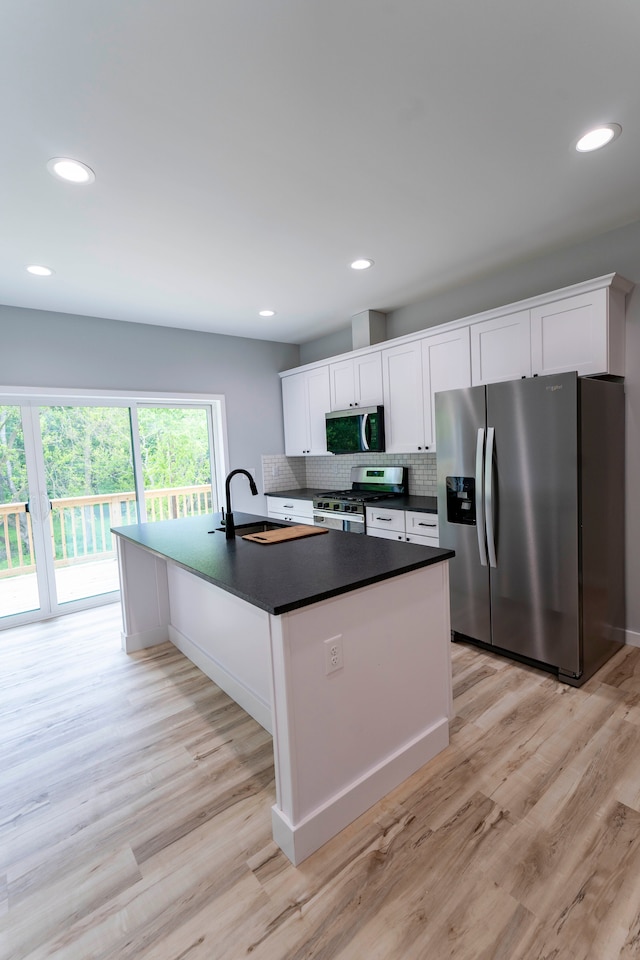 26015 E Huron River Dr, Flat Rock, MI 48134 - kitchen featuring stainless steel appliances, dark countertops, light wood finished floors, white cabinetry, and recessed lighting