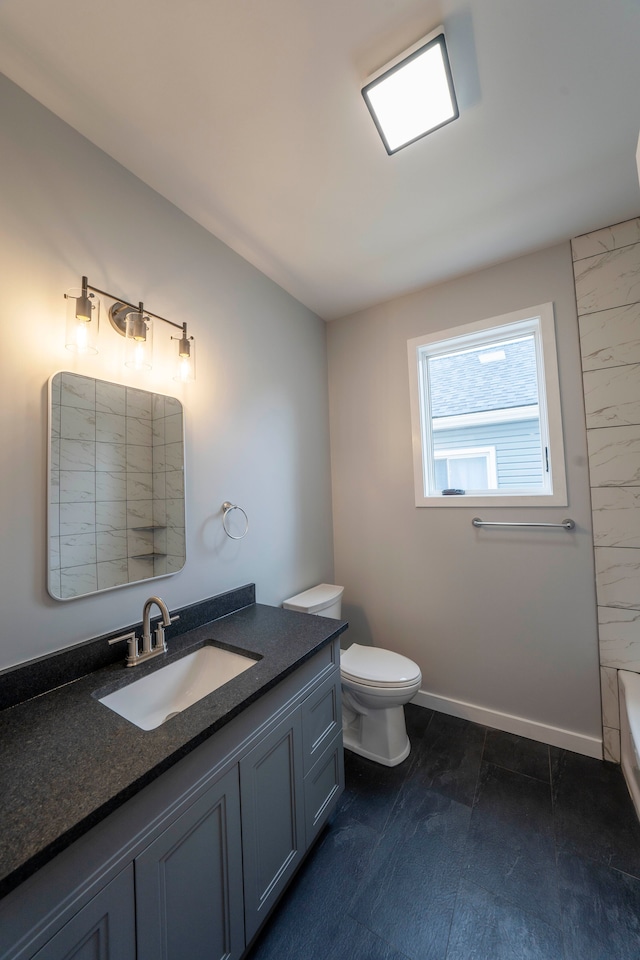 26015 E Huron River Dr, Flat Rock, MI 48134 - full bath with vanity, toilet, a tub to relax in, and baseboards