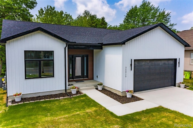 26015 E Huron River Dr, Flat Rock, MI 48134 - modern farmhouse with a garage, roof with shingles, concrete driveway, and a front lawn