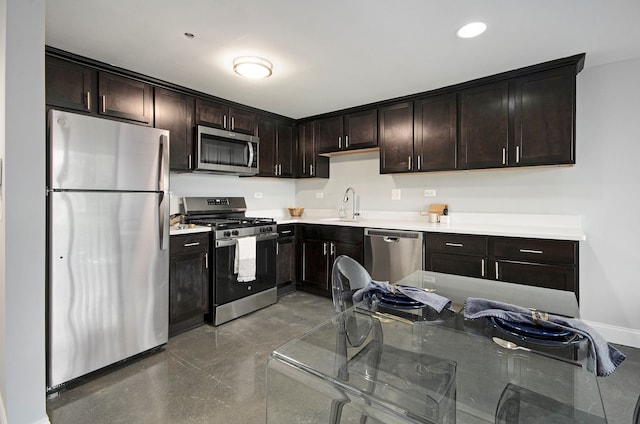 3320 Spinnaker Ln Unit 2E, Detroit, MI 48207 - kitchen with appliances with stainless steel finishes, a sink, baseboards, concrete flooring, and dark brown cabinets