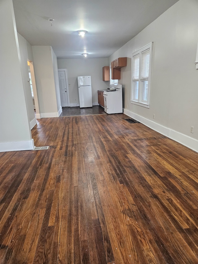 interior space featuring baseboards, dark wood-type flooring, and visible vents