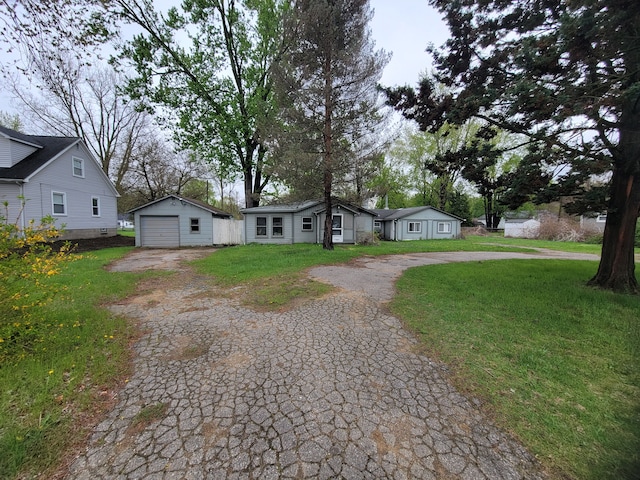 8558 Messmore Rd, Shelby Twp, MI 48317 - view of front facade with a garage, asphalt driveway, an outdoor structure, and a front lawn