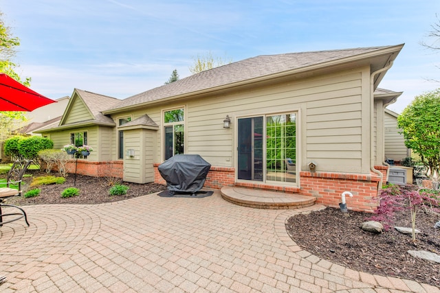 back of property with a patio area and brick siding