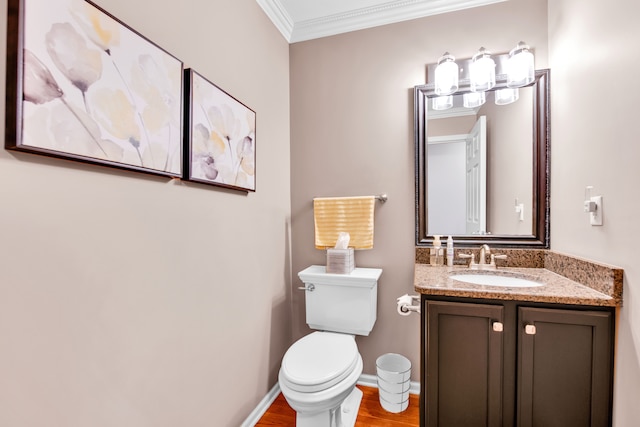bathroom with crown molding, vanity, wood finished floors, toilet, and baseboards