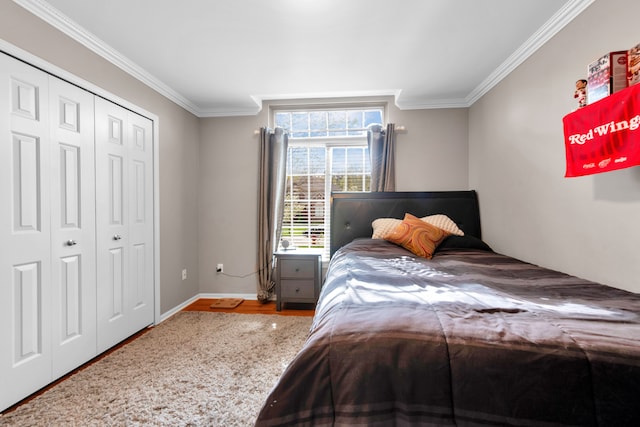bedroom with ornamental molding, wood finished floors, a closet, and baseboards