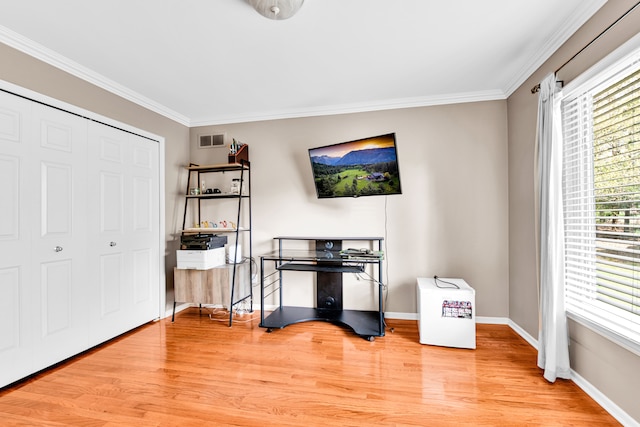 interior space with baseboards, crown molding, visible vents, and wood finished floors