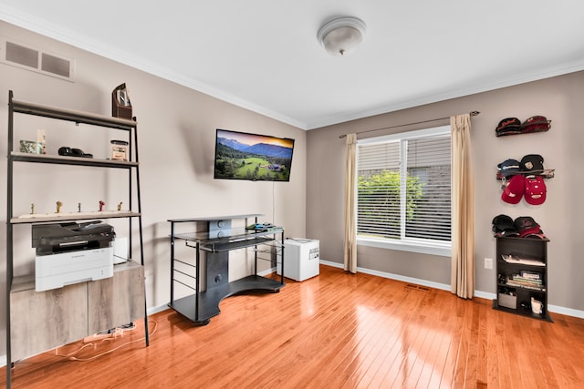 office featuring hardwood / wood-style floors, crown molding, and baseboards