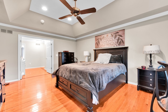 bedroom featuring light wood-style flooring, baseboards, a raised ceiling, and a ceiling fan