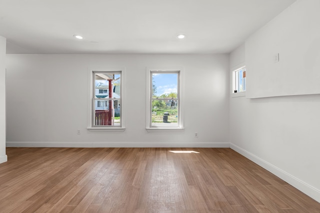 spare room with light wood finished floors, baseboards, and recessed lighting