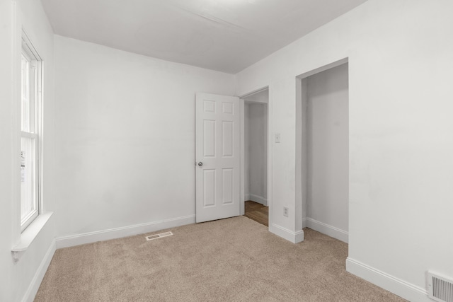unfurnished bedroom with carpet and baseboards