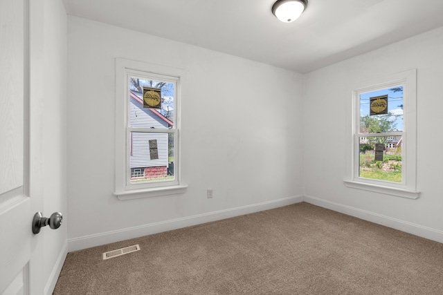 spare room featuring carpet and baseboards