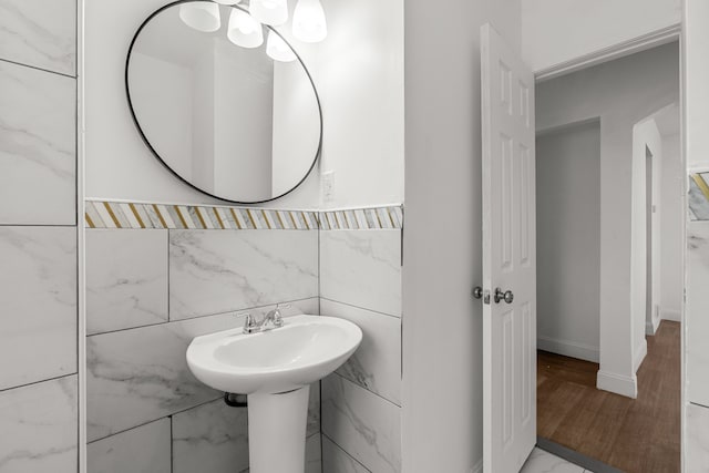 bathroom with tile walls, baseboards, and wood finished floors