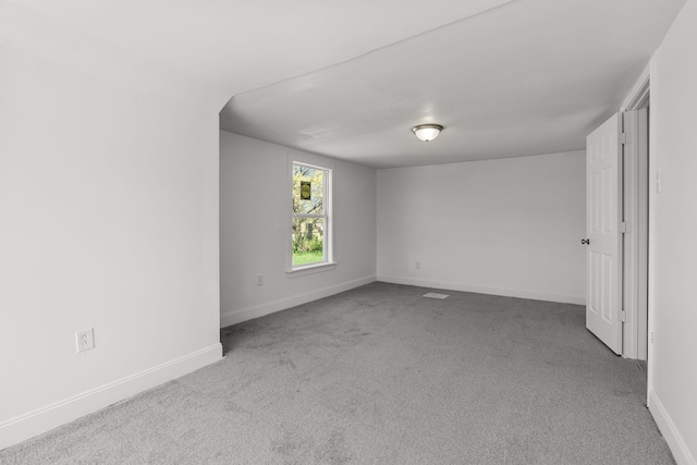 spare room featuring carpet floors and baseboards