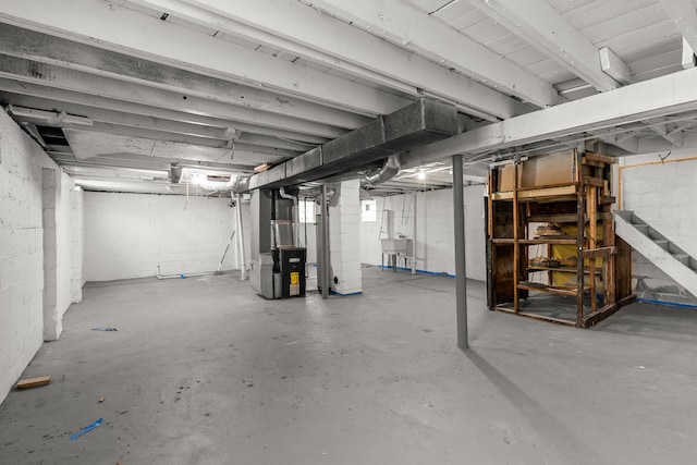 unfinished basement with a sink and heating unit