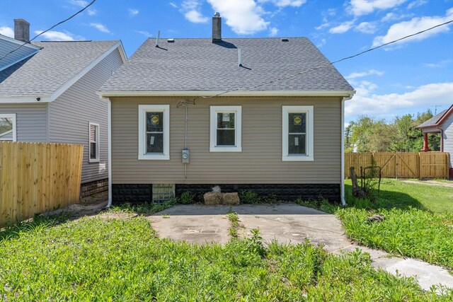 rear view of property with roof with shingles and a patio