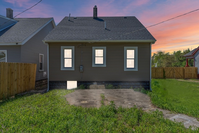 back of property featuring a patio area, a shingled roof, a chimney, and a gate