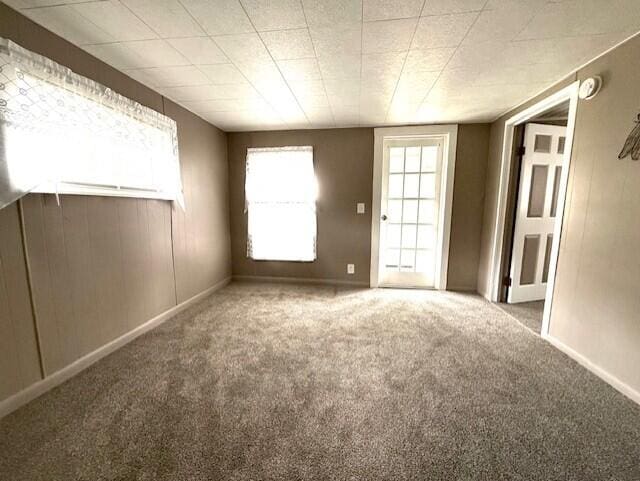 carpeted empty room with baseboards