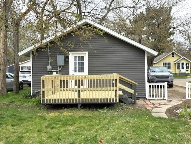 rear view of property with a yard and a deck