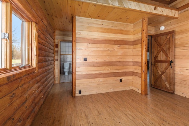 empty room with a wealth of natural light, wood ceiling, and wood finished floors