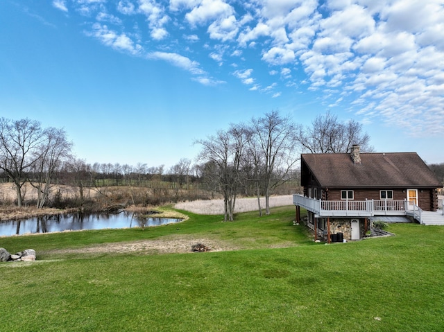 view of yard with a deck with water view