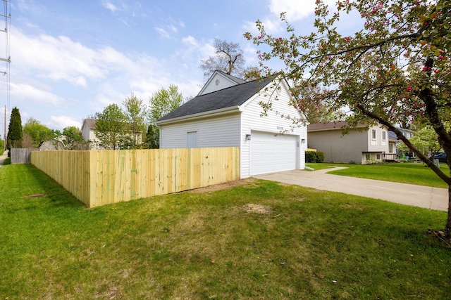 exterior space featuring a lawn, driveway, fence, and a garage