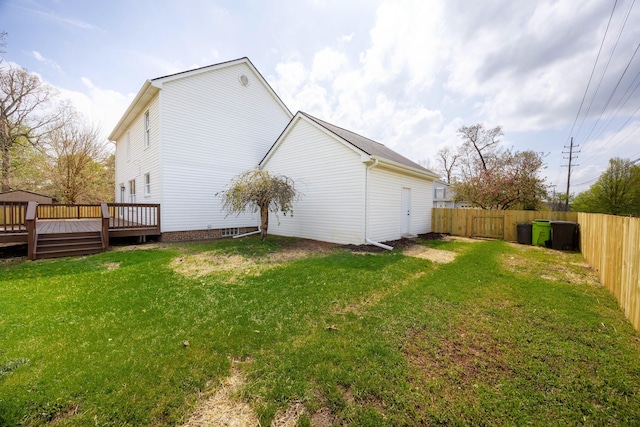view of side of property featuring a yard, a wooden deck, and a fenced backyard