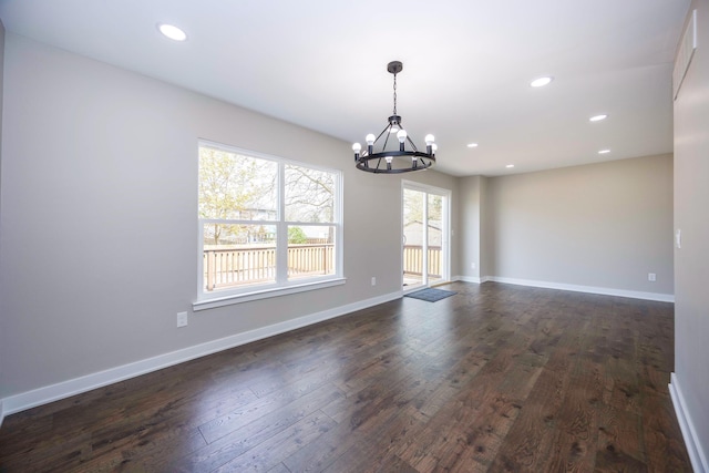 unfurnished room featuring an inviting chandelier, dark wood-type flooring, and recessed lighting