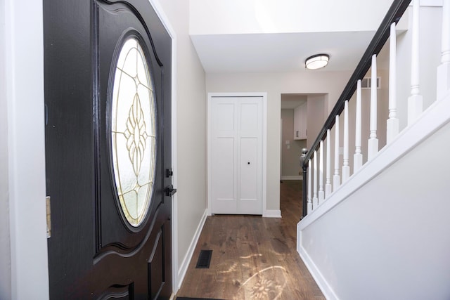 entryway with baseboards, stairs, visible vents, and wood finished floors