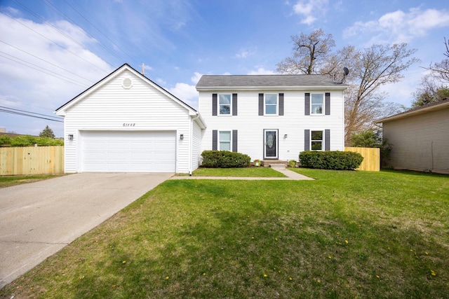 colonial inspired home featuring a front yard, driveway, a garage, and fence