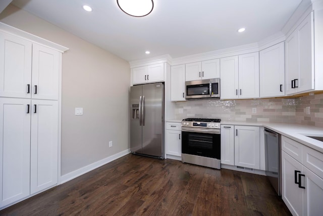 kitchen with backsplash, dark wood-style flooring, light countertops, and appliances with stainless steel finishes