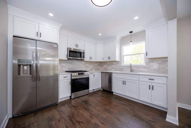 kitchen featuring dark wood-style flooring, a sink, white cabinetry, light countertops, and appliances with stainless steel finishes