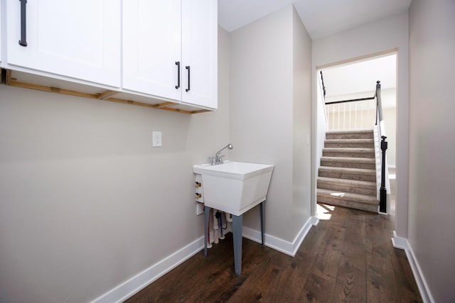 washroom with baseboards and dark wood-style floors