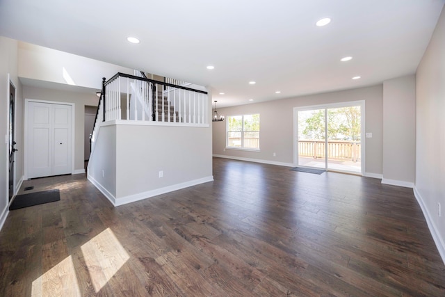 unfurnished living room featuring stairway, baseboards, dark wood-type flooring, and recessed lighting
