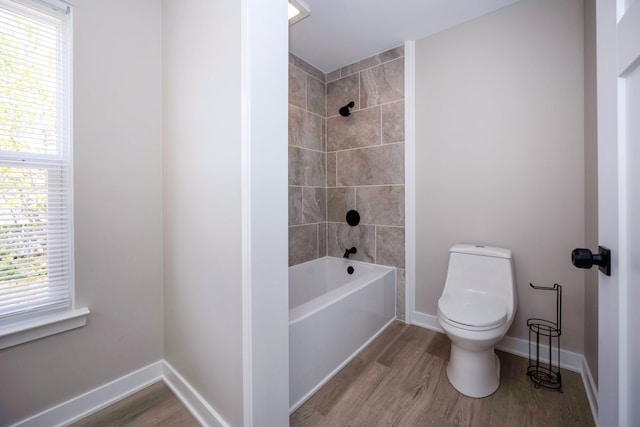 bathroom featuring toilet, a wealth of natural light, and wood finished floors