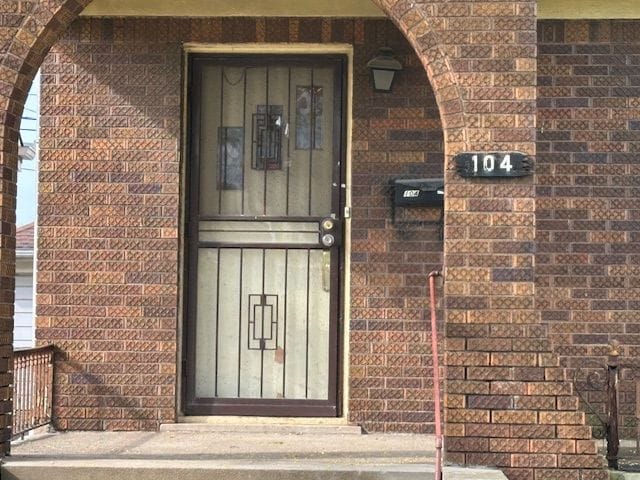 doorway to property featuring brick siding