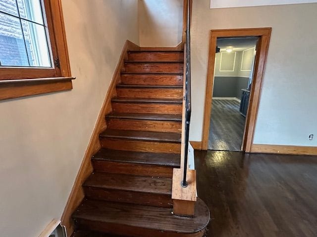 stairs with wood finished floors and baseboards