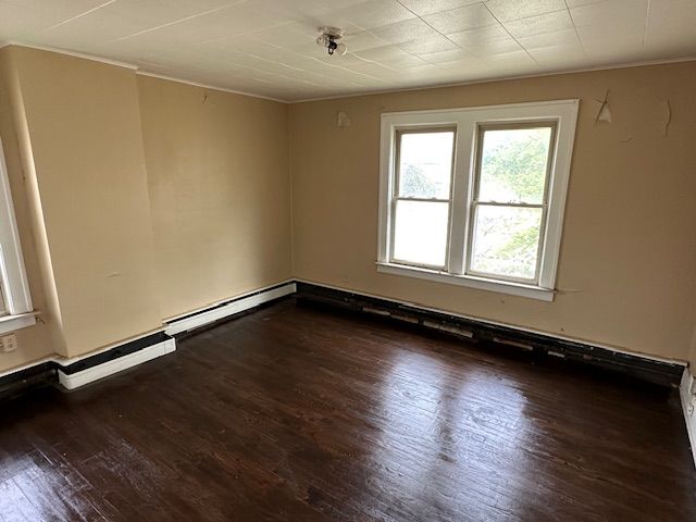 unfurnished room featuring crown molding and wood-type flooring