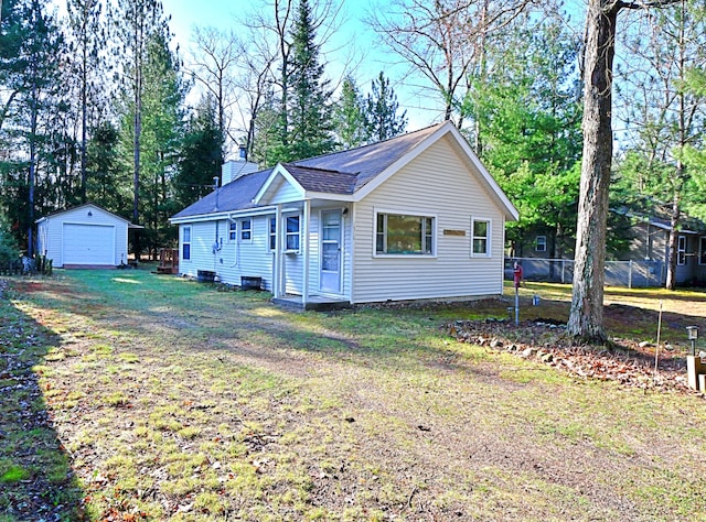 view of front of house with a garage, an outdoor structure, roof with shingles, and driveway