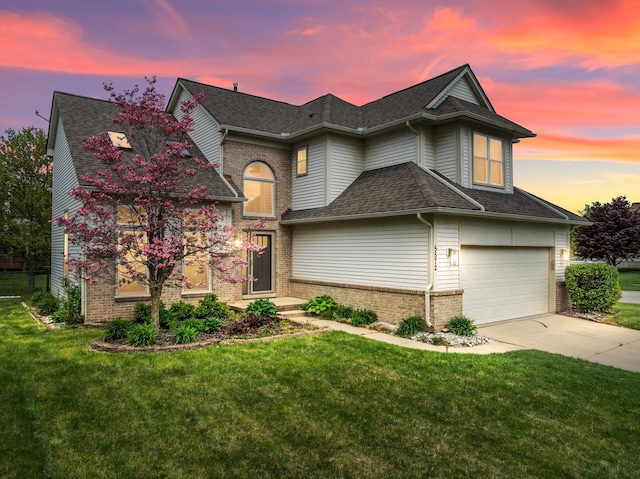 traditional-style house featuring driveway, a shingled roof, brick siding, and a lawn