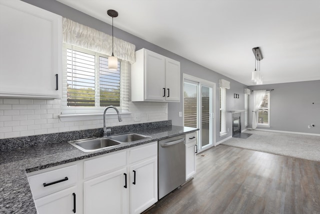 kitchen with dishwasher, a sink, white cabinets, and plenty of natural light