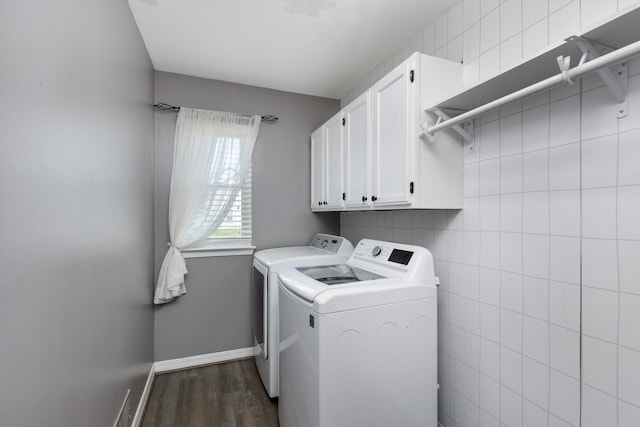 clothes washing area with washer and clothes dryer, cabinet space, dark wood-style floors, and baseboards