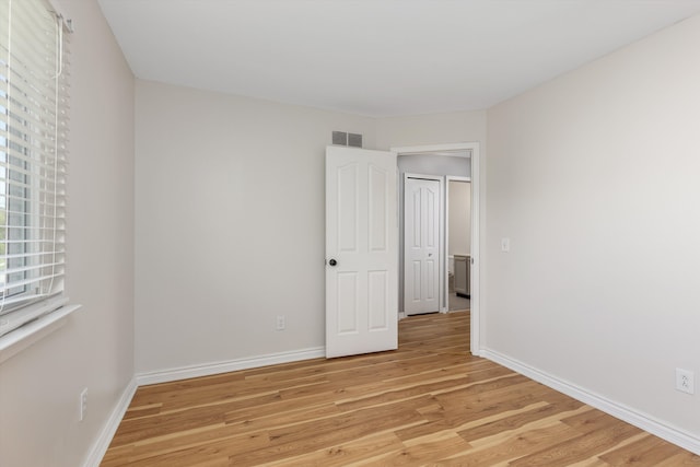 spare room featuring light wood finished floors and baseboards