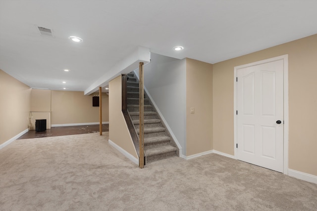 finished basement featuring carpet flooring, stairway, baseboards, and recessed lighting