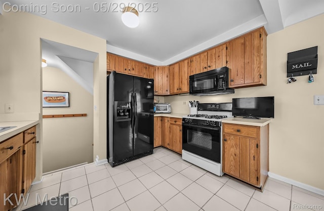 1930 N Wilson Ave, Royal Oak, MI 48073 - kitchen with black appliances, brown cabinetry, light countertops, light tile patterned floors, and baseboards
