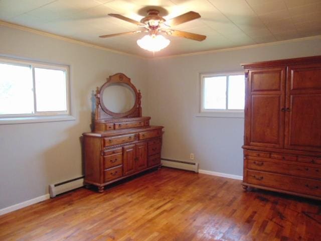 bedroom featuring baseboard heating, crown molding, light wood finished floors, baseboards, and ceiling fan